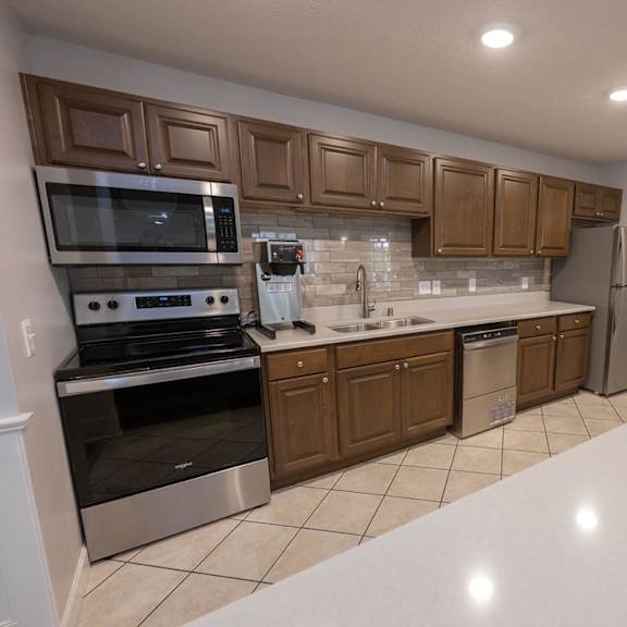 a kitchen with wooden cabinets and a white counter top