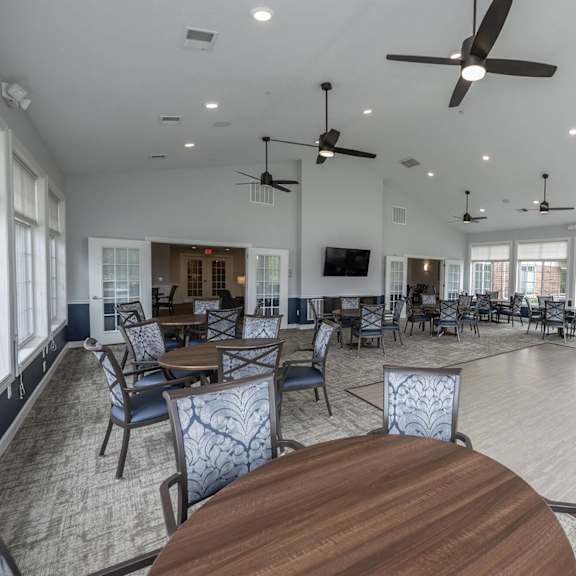 a large room with multiple ceiling fans and tables and chairs