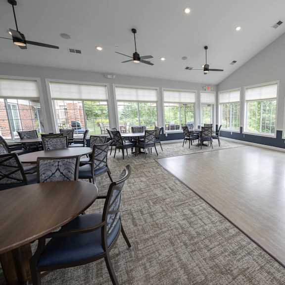 a large room with large windows and tables and chairs