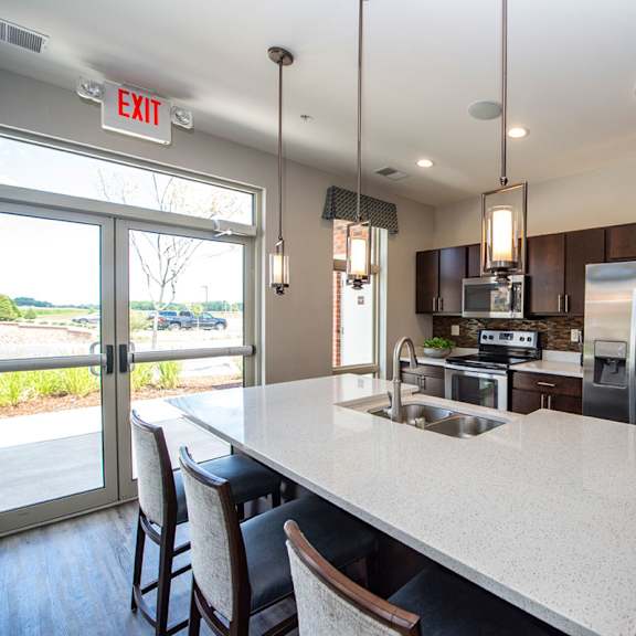 a kitchen with a large island and a stainless steel refrigerator
