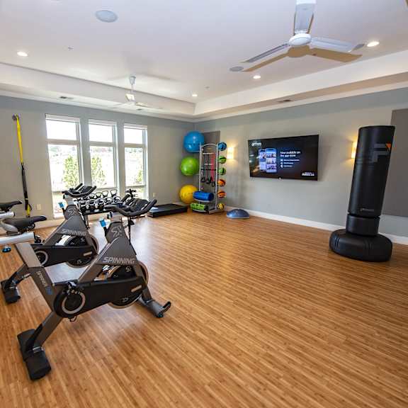 a gym with exercise equipment and a tv on the wall