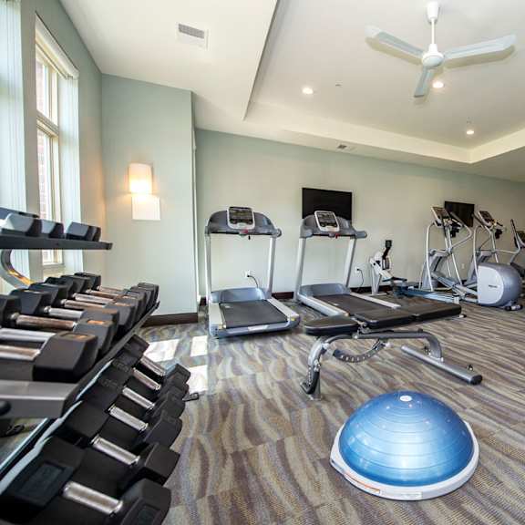 a gym with treadmills and weights on the floor