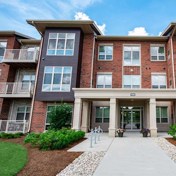 an apartment building with a sidewalk in front of it
