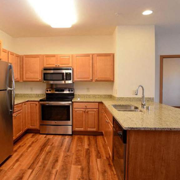 gourmet kitchens with islands, caesarstone countertops, and decorative backsplash at highlands at riverwalk apartments 55+, mequon, 53092
