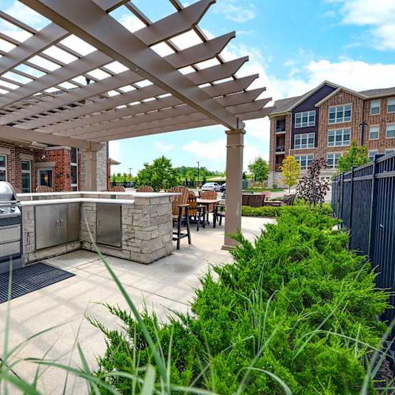a patio with a grill and a pergola