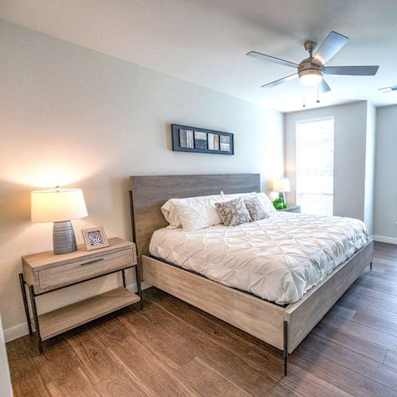a bedroom with a large bed and a ceiling fan