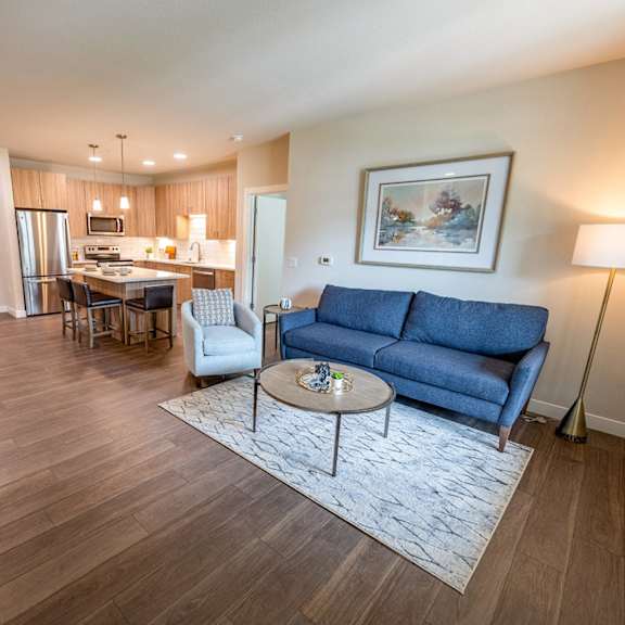 a living room and kitchen with a couch and a table