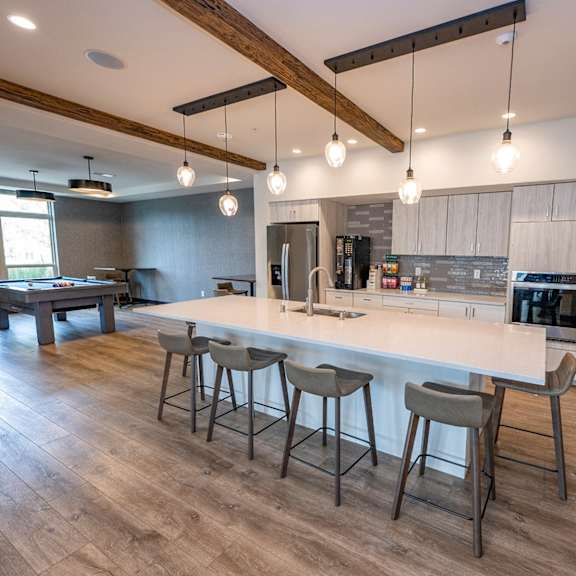 a large kitchen with a large island with bar stools and a pool table