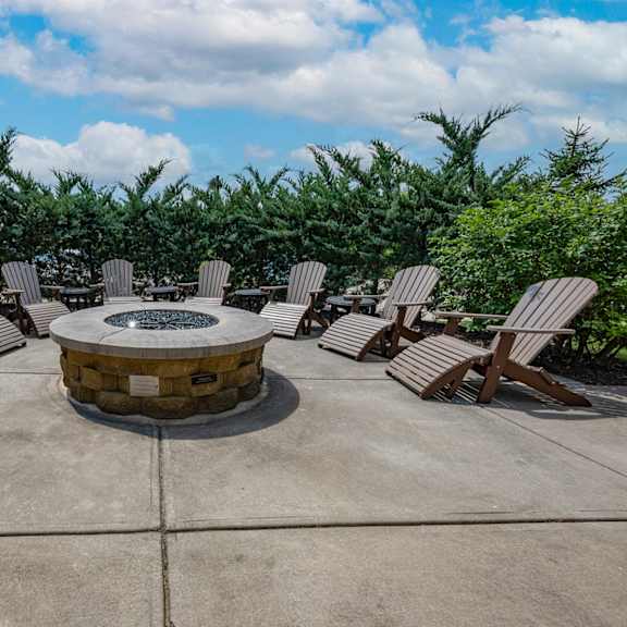an outdoor patio with chairs and a fire pit