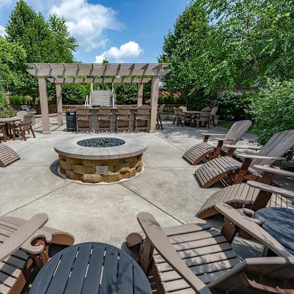 a patio with chairs and a fire pit