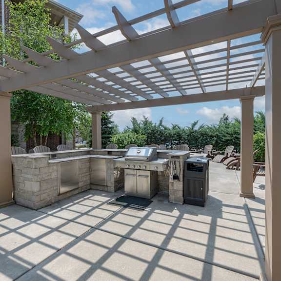 a patio with a grill and a pergola