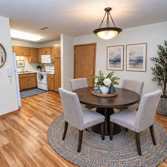 a dining room with a round table and chairs.
