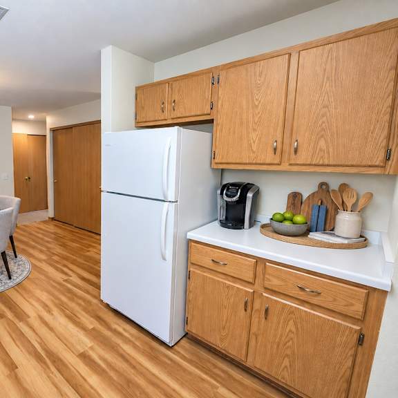 a kitchen with a white refrigerator and wooden cabinets.