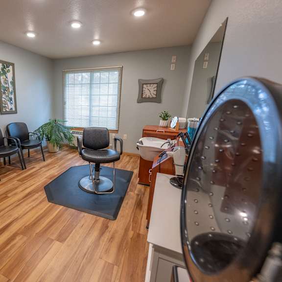 a room with a washing machine on the right and a chair in the middle.