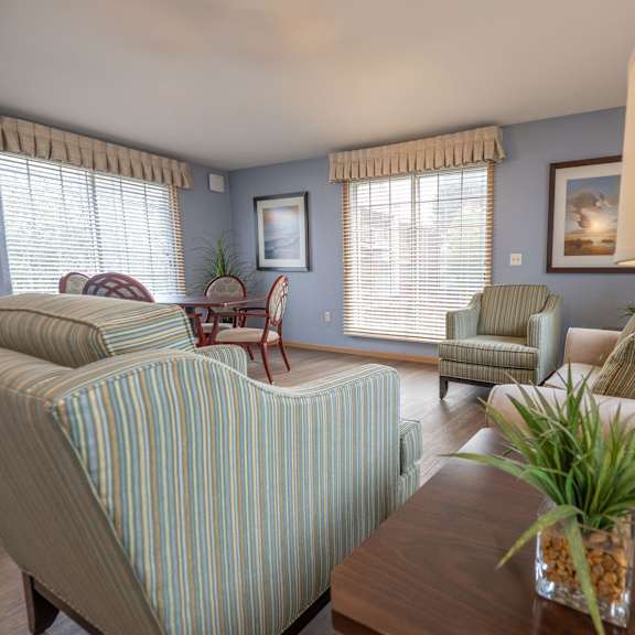 a living room with a striped couch and a wooden coffee table.