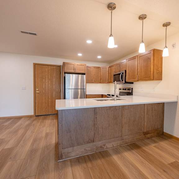 a kitchen with wooden cabinets and a stainless steel refrigerator.