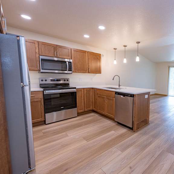 a kitchen with wooden floors and stainless steel appliances.