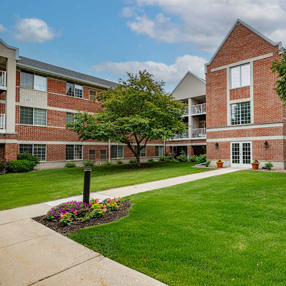 a red brick building with a green lawn in front.