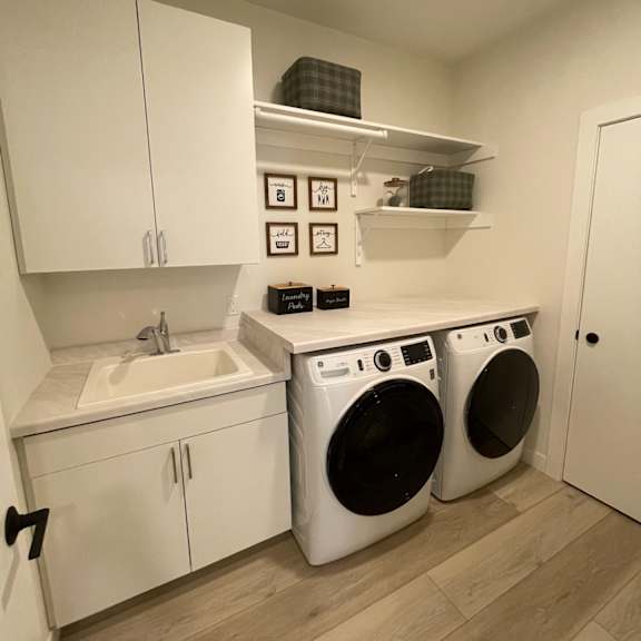 a small laundry room with a sink, washer and dryer.