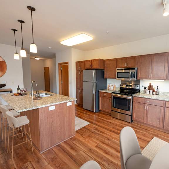 a kitchen and dining area with wooden cabinets and stainless steel appliances