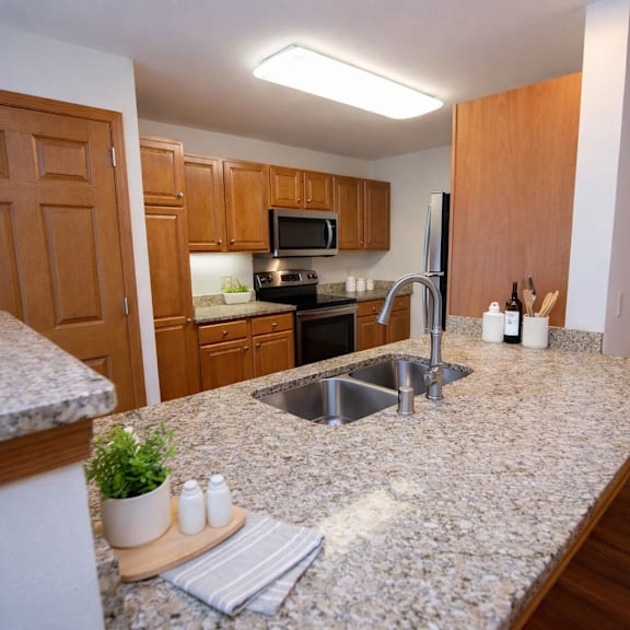 a kitchen with granite countertops and wooden cabinets.