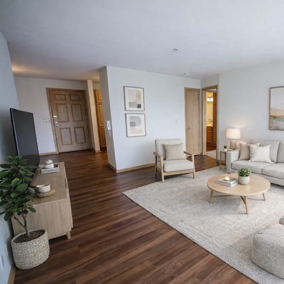 a living room with a white couch, a wooden coffee table, and a painting on the wall.