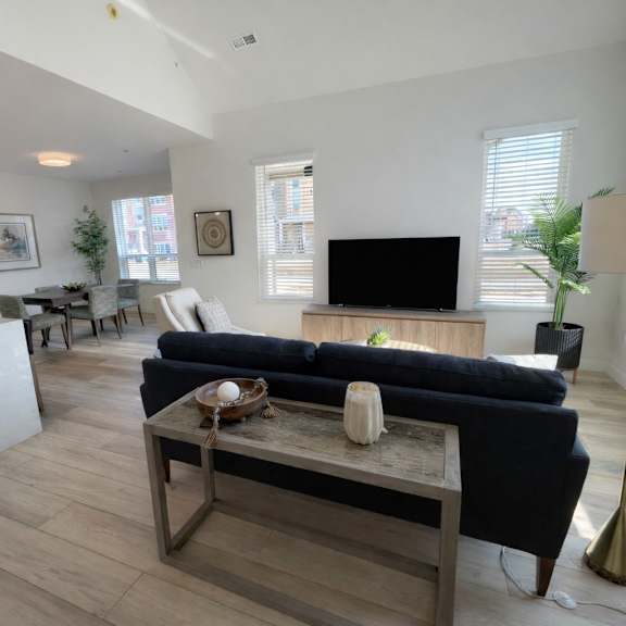 a living room with a black couch and a wooden coffee table.