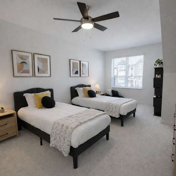 a bedroom with two beds and a ceiling fan.