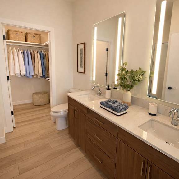 a bathroom with a wooden floor and white walls.