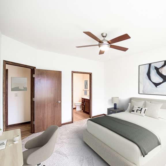 a bedroom with a large bed and a ceiling fan