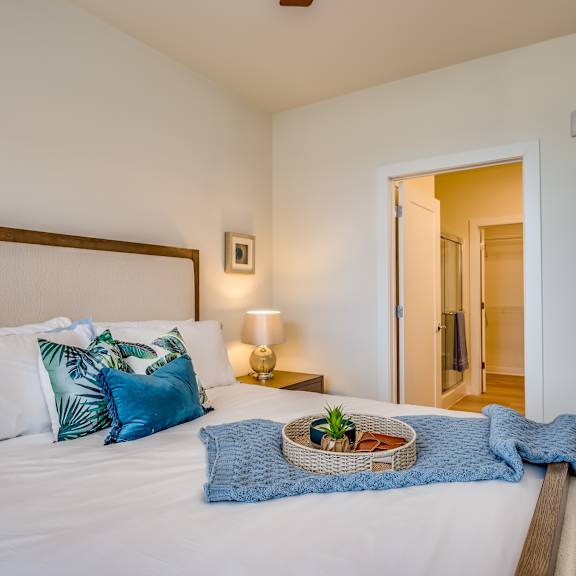 a bedroom with a large bed with pillows and a basket on it
