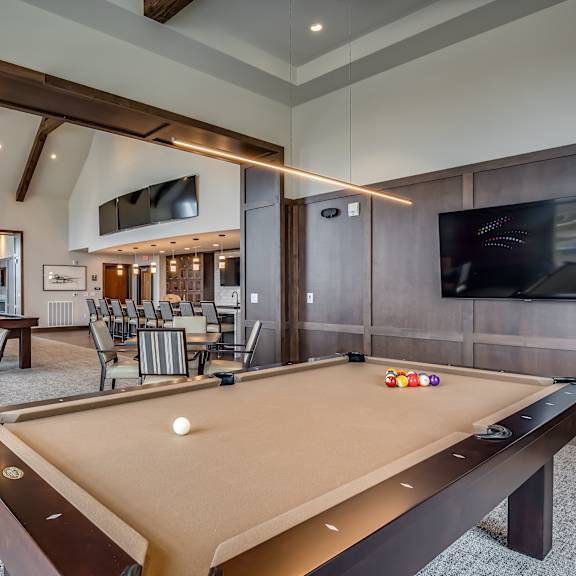 a clubhouse with a pool table and a tv