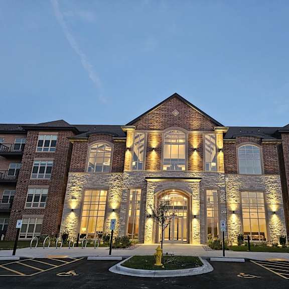 an exterior view of a building at night with lights on it