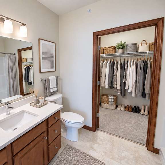 a bathroom with a toilet, sink, and mirror.