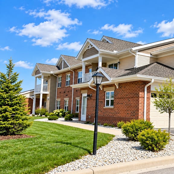 a large, modern house with a brick facade and a driveway.