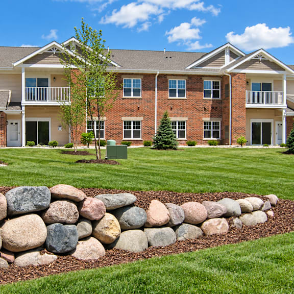 a large house with a stone wall in front.