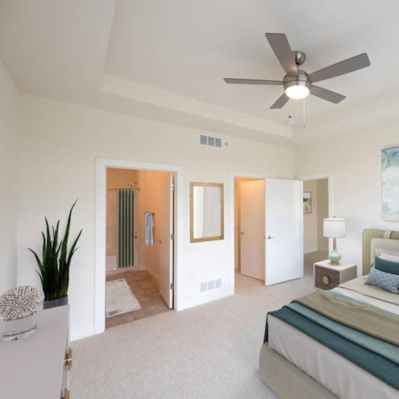a bedroom with a large bed and a ceiling fan