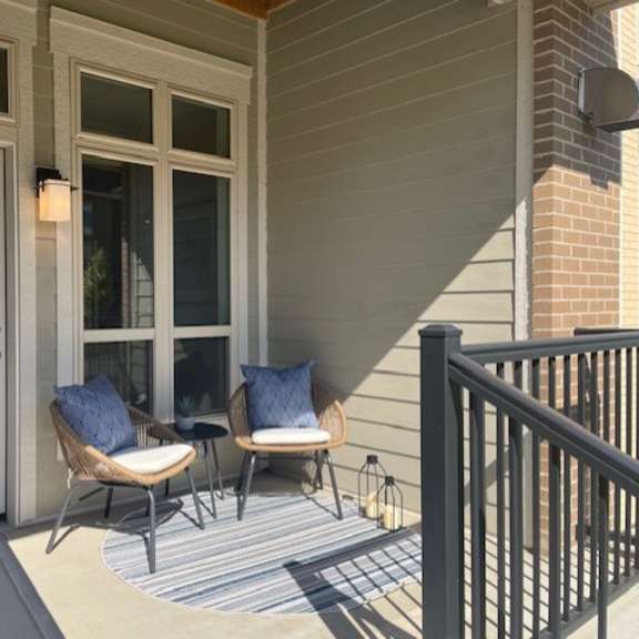a porch with two chairs and a white door