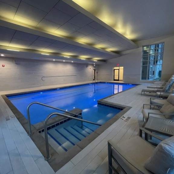 a large indoor swimming pool with a staircase leading down to it.