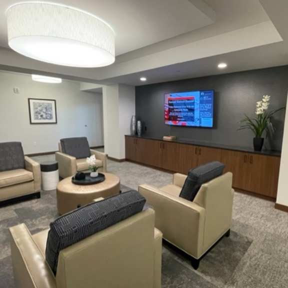 a lobby with chairs and a desk and a tv