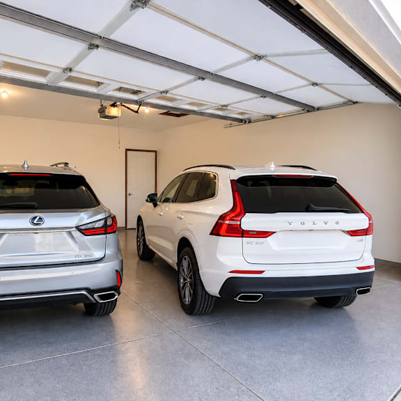 two cars are parked in a garage.