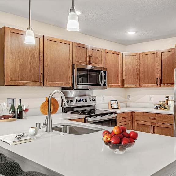a kitchen with a white counter top and wooden cabinets.