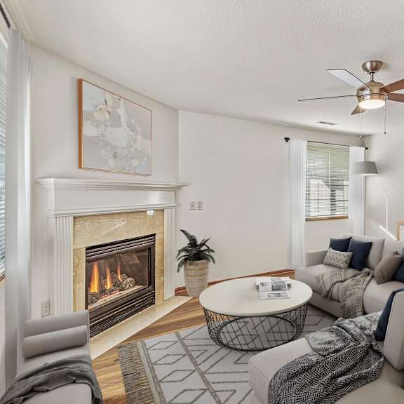 a living room with a fireplace and a grey couch.