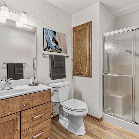 a bathroom with a toilet, sink, and shower.