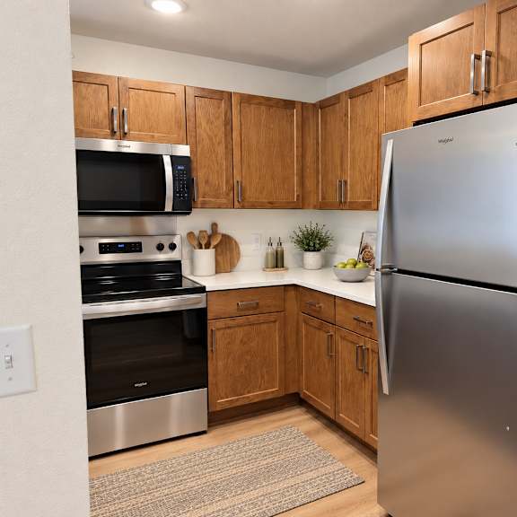 a kitchen with a refrigerator, oven, and microwave.