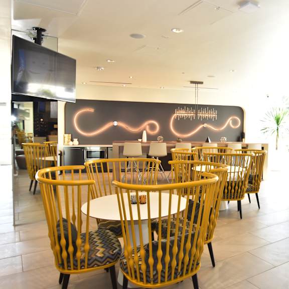 community dining area with stylish yellow chairs at 360 luxury apartments, san diego, ca 92122