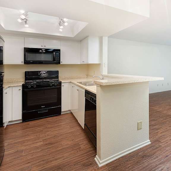 kitchen with black appliances at fulton gardens apartments, california