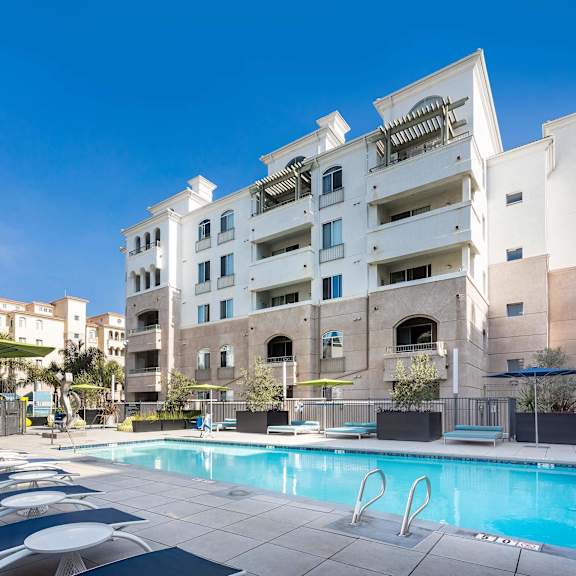 a large white building with a pool in front. at la jolla crossroads apartments, san diego