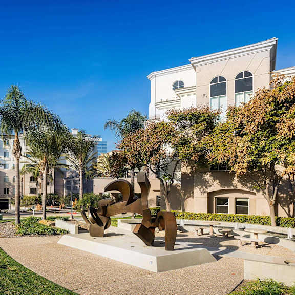 a sculpture in a park with a building in the background. at la jolla crossroads apartments, san diego, california
