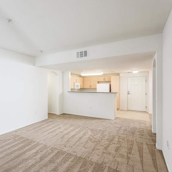 a large empty room with a carpeted floor and white walls. at la jolla crossroads apartments, california